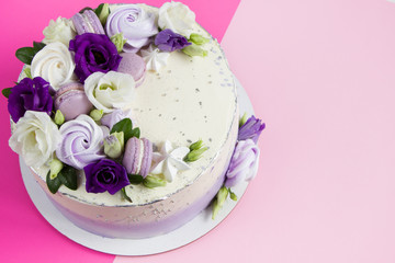 Beautiful purple cake decoraited of  fresh flowers, macaroons and meringue.  Love concept , Wedding cake, birthday cake, Mother's day, 8 march, women's day, design template, pink background