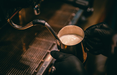 bartender preparing hot milk on coffee machine