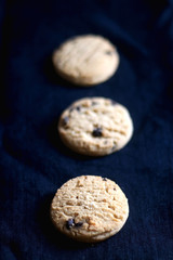 Chocolate chip cookies on dark blue background. Selective focus.