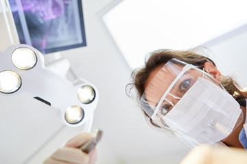 Young dentist with surgical mask and visor