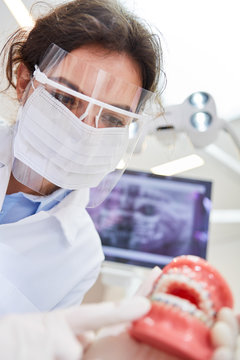 Woman As A Dentist With Surgical Mask And Visor