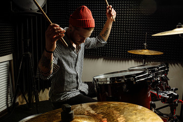 energetic caucasian drummer man professionally play on drums, he enjoy performing music in studio,...