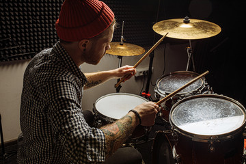 energetic caucasian drummer man professionally play on drums, he enjoy performing music in studio, preparing for concert. rock and roll, music, instruments concept