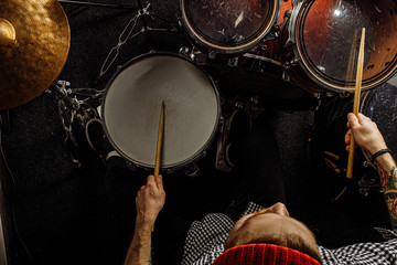 top view on energetic caucasian drummer man professionally play on drums, he enjoy performing music in studio, preparing for concert. rock and roll, music, instruments concept