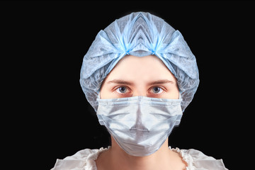Woman nurse doctor wearing medical mask and hat on black background. Protection from coronavirus infection, health care concept