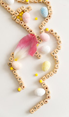 Wooden letters multicolored eggs flowers on a white background