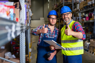 Workers in warehouse with thumb up