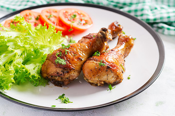 Grilled chicken legs with spices and fresh vegetables. Baked drumsticks.