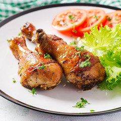 Grilled chicken legs with spices and fresh vegetables. Baked drumsticks.