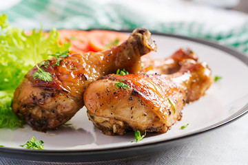 Grilled chicken legs with spices and fresh vegetables. Baked drumsticks.