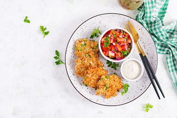 Homemade grilled chicken with green peas patties on a plate with tomatoes salad. Chicken cutlets....