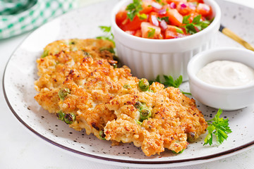 Homemade grilled chicken with green peas patties on a plate with tomatoes salad. Chicken cutlets.