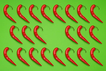 Red chili peppers in a pattern on green background