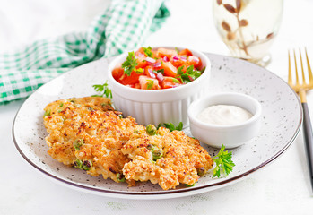 Homemade grilled chicken with green peas patties on a plate with tomatoes salad. Chicken cutlets.