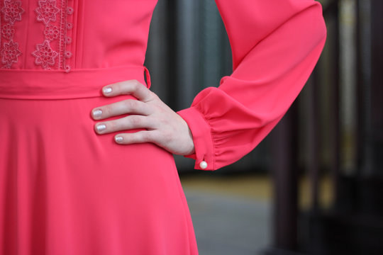 The girl put her hand on her waist. In a beautiful rose-orange dress. Glare plan. Dress for nikaha