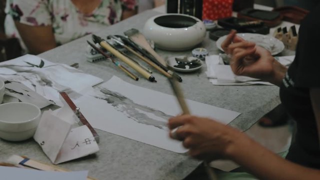 Women hands painting bamboo Japanese style. Traditional Japanese calligraphy and drawing sumi-e