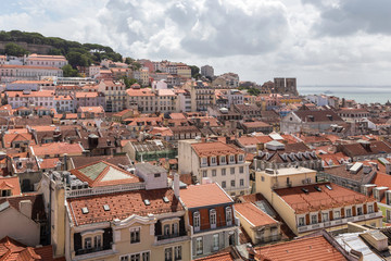 Obraz premium Top view on Lisbon, tiled roofs of houses and the Tagus River. Lisbon, Portugal. Summer sunny day