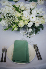 wedding table setting with flowers and green 
napkins