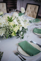 wedding table setting with flowers and green 
napkins