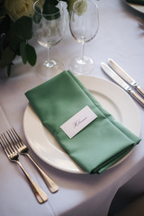wedding table setting with flowers and green 
napkin