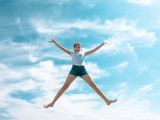 teenage girl jumping high, sky as background