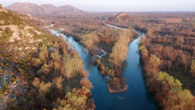 River fork in autumn. Blue stream of water flowing through colorful landscape. Aerial footage. Zabljak Crnojevica in Montenegro.