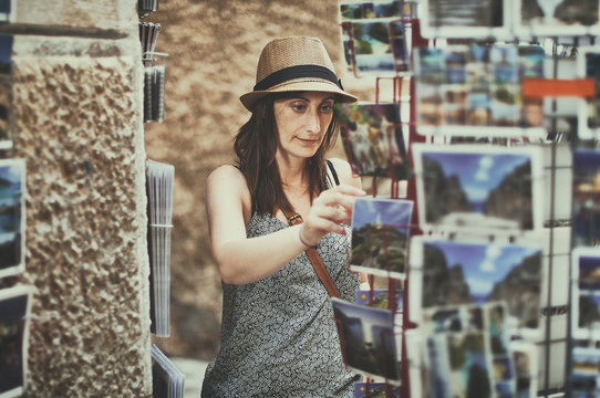 Woman choosing a postcard, Majorca, Balearics, Spain