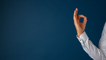 Hand of a businessman showing an ok gesture with his fingers - obrazy, fototapety, plakaty