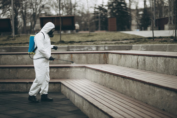 Cleaning and Disinfection at town complex amid the coronavirus epidemic Professional teams for disinfection efforts Infection prevention and control of epidemic Protective suit and mask