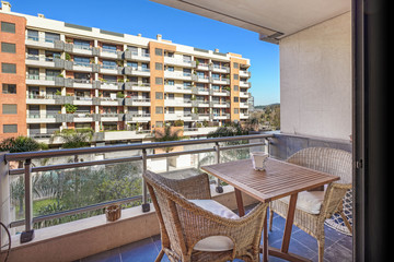 Apartment exterior on the balcony with two chairs and a table.