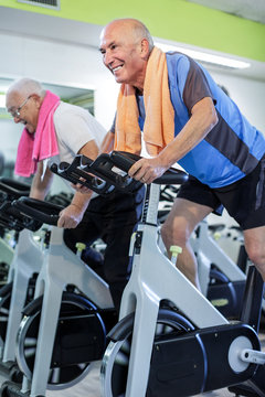 Uomini anziani si allenano in una palestra con lo spinning
