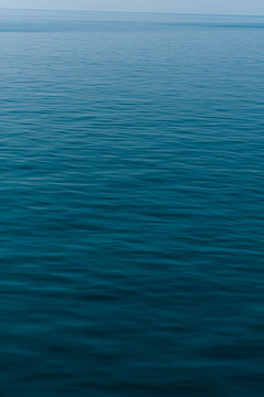 Calm infinite blue sea ocean water background