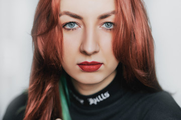 Fototapeta premium portrait of a young girl with red lips and red hair