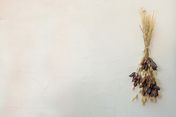 Naklejka premium Preserved flowers bunch on a white wall 