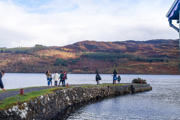 Group of young people enjoying  a sunny day in a beautiful lake with mountains