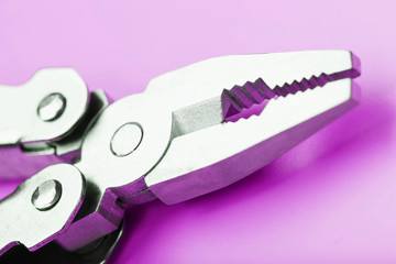 Multitool is a multi-functional tool on a pink background. The concept of an open, flying multi-tool with free space.