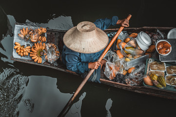 Man on boat in Damnoen Saduak Floating Market in Bangkok Thainland 