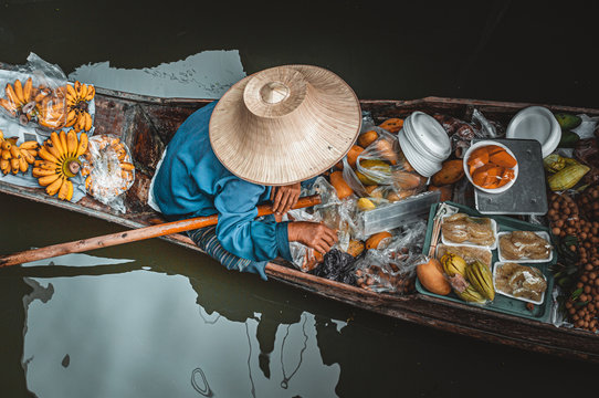 Man on boat in Damnoen Saduak Floating Market in Bangkok Thainland 