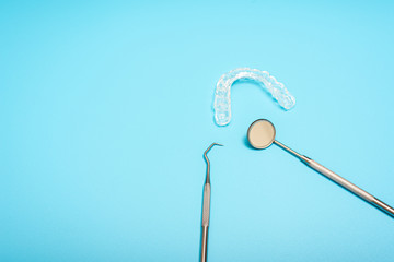 Blue background for dental clinics with dental aligner and mount splints, copy space.