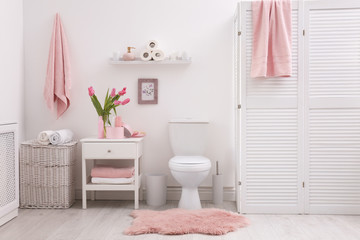 Interior of stylish bathroom with toilet bowl and decor elements