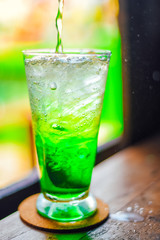 green juice water whit soda in glass on wood table at cafe. Summer  drink
