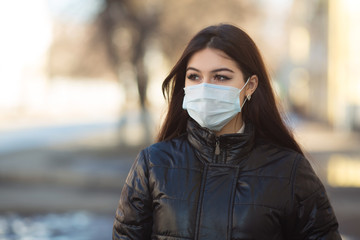 beautiful young woman in medical face mask outdoors