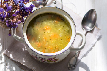 pea soup on chicken broth in pan on wooden background