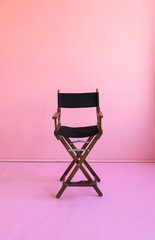Directors chair isolated on a pink background. Space for text..Vacant chair. The concept of selection and casting.