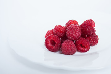 raspberries in a bowl isolated on white