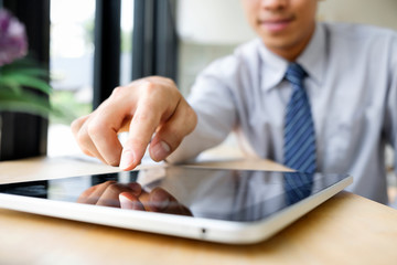 Close up of businessman working on digital tablet.