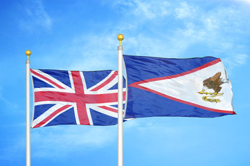 Fototapeta na wymiar United Kingdom and American Samoa two flags on flagpoles and blue cloudy sky