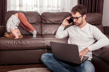 Young busy father trying to work at home with his children. Self isolation. Stay home concept. Freelancer.