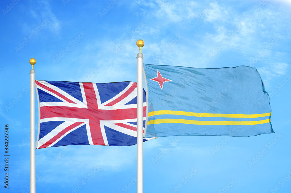 Wall mural united kingdom and aruba two flags on flagpoles and blue cloudy sky