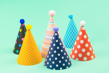 Colorful birthday caps on mint background.